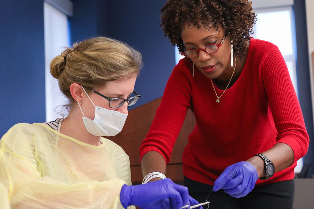 School of Nursing faculty member insuring a nursing student