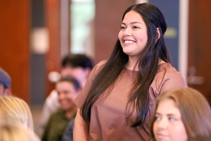 School of Nursing Student stands in a classroom smiling