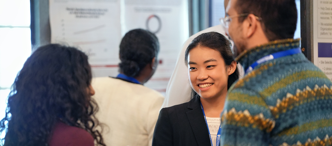 A Duke University MSN student smiles and discusses health equity with a small group of fellow adult-gerontology nursing students. 