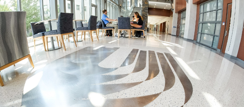 The interior of the Duke University School of Nursing, including the floor. On the floor is a large Duke emblem in silver. 