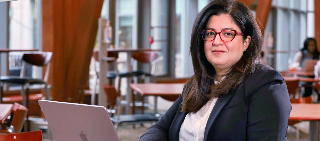 A female Duke University School of Nursing faculty member deciphers health informatics on a laptop. 