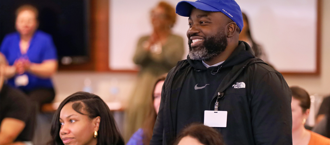 A male Duke University Nursing MSN laughs in an MSN neonatal nurse practitioner classroom setting.