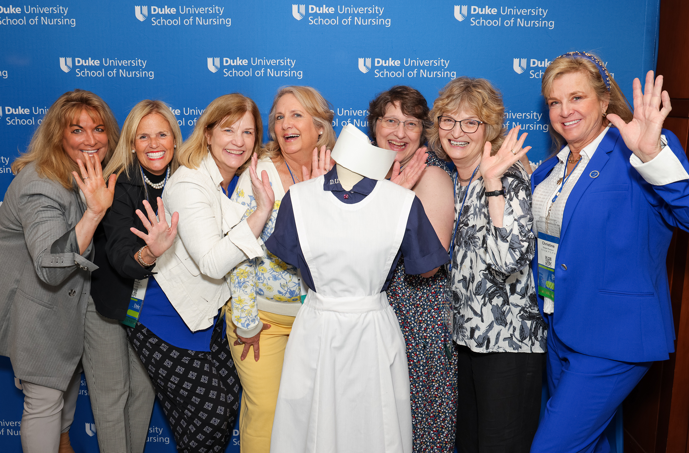 School of Nursing Alumni group posing with a nursing uniform