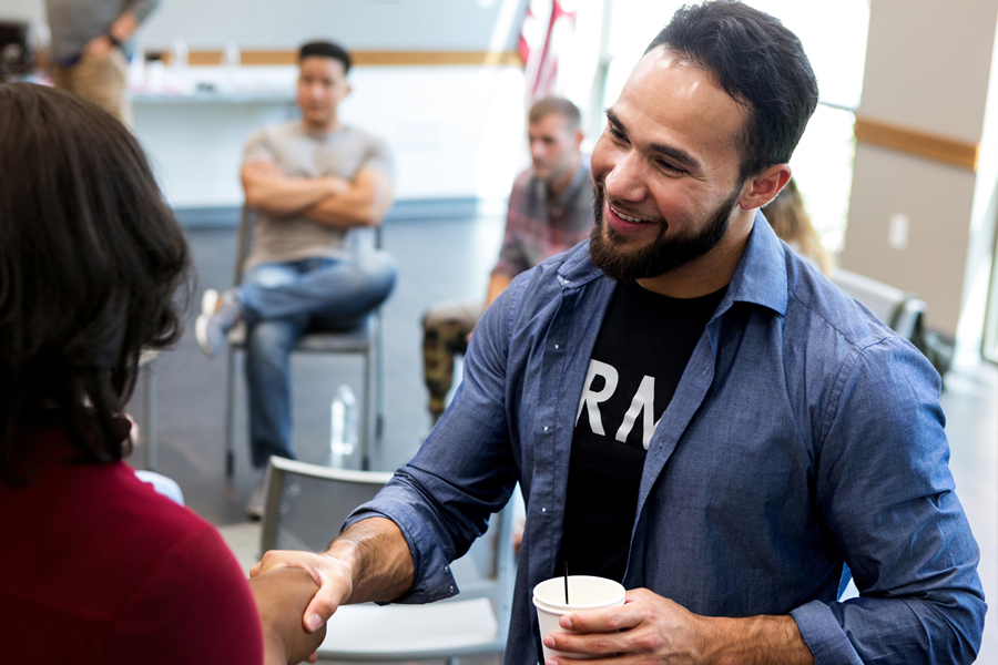 Army Veteran shaking heads with a student