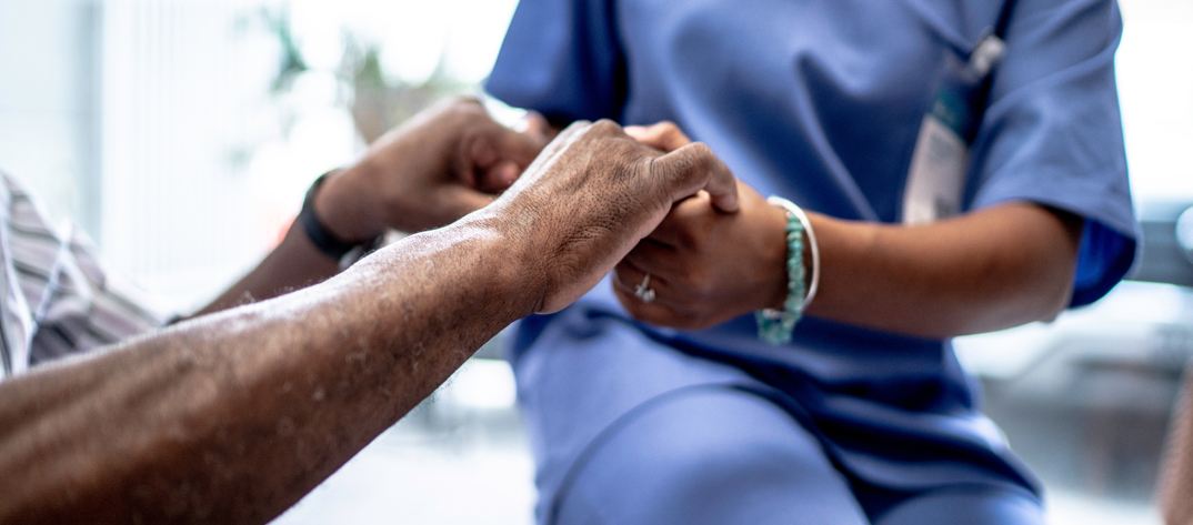 Palliative Care Nurse holding hands of a patient