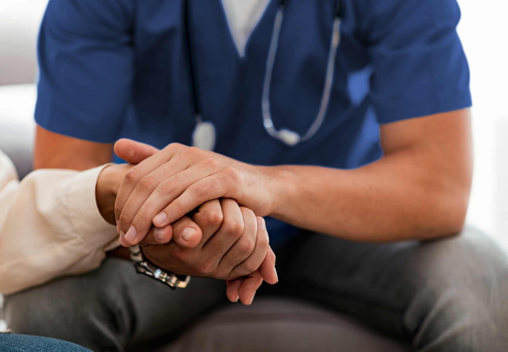 Nurse holding a patient's hand