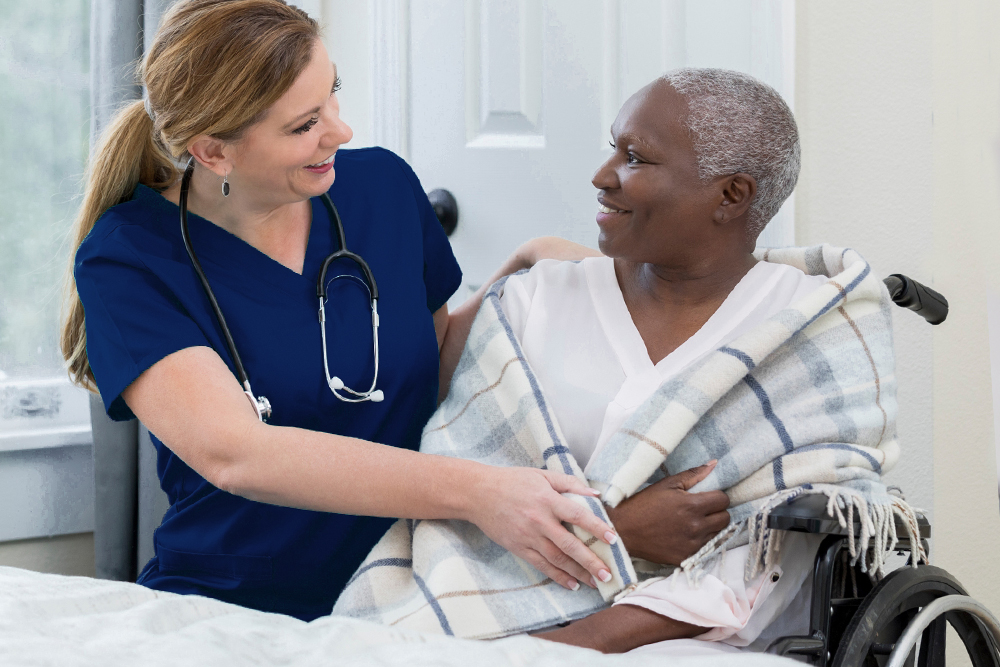 Nurse and patient at bedside smiling to each other