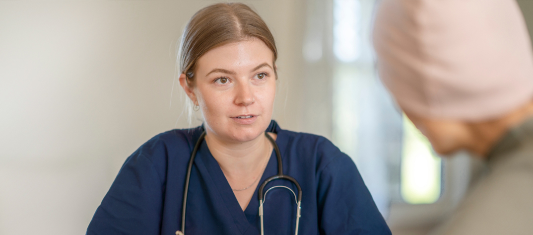 Nursing speaking with patient at a table