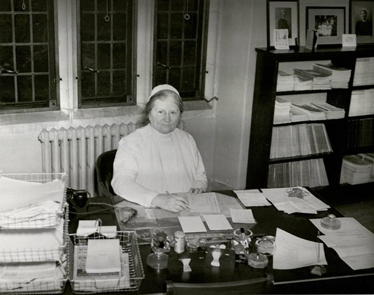 Bessie Baker sitting at her desk