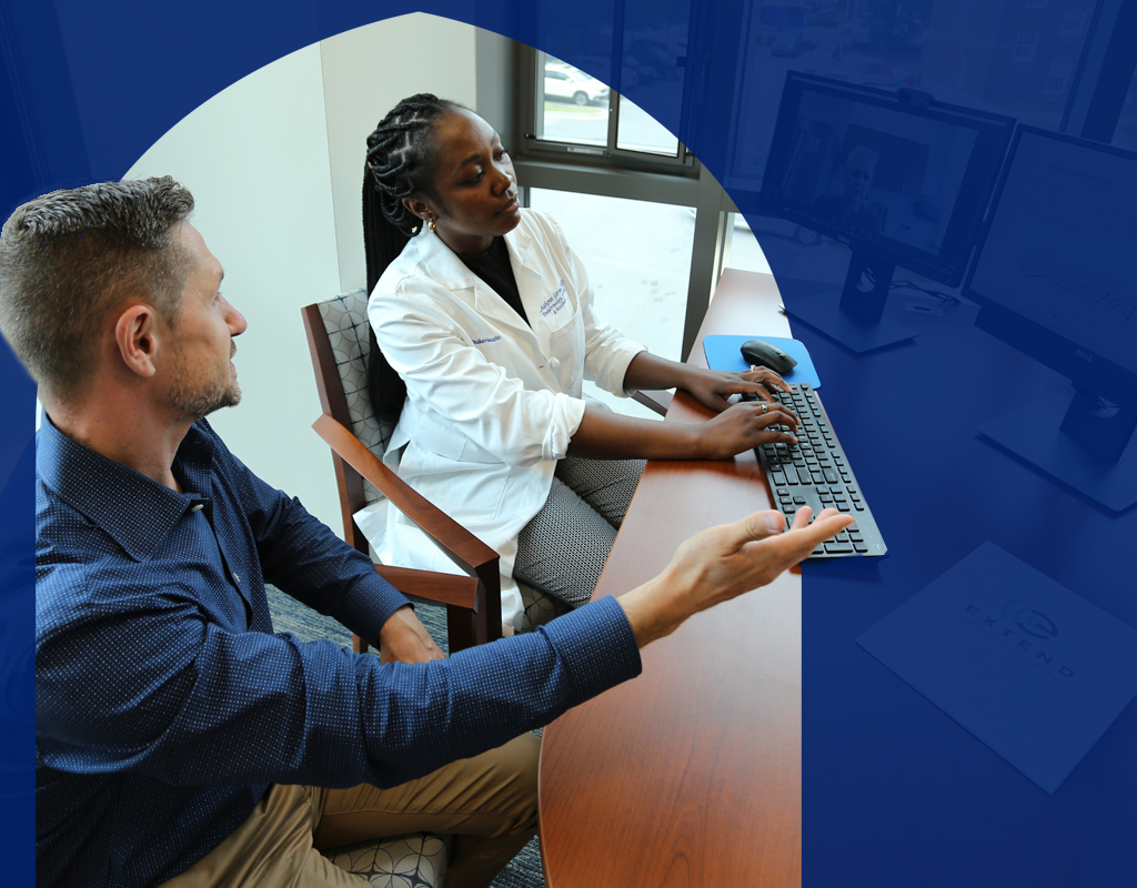 Two Nurses discussing data on a computer screen