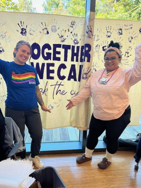 Two WHNP students with a domestic violence awareness banner