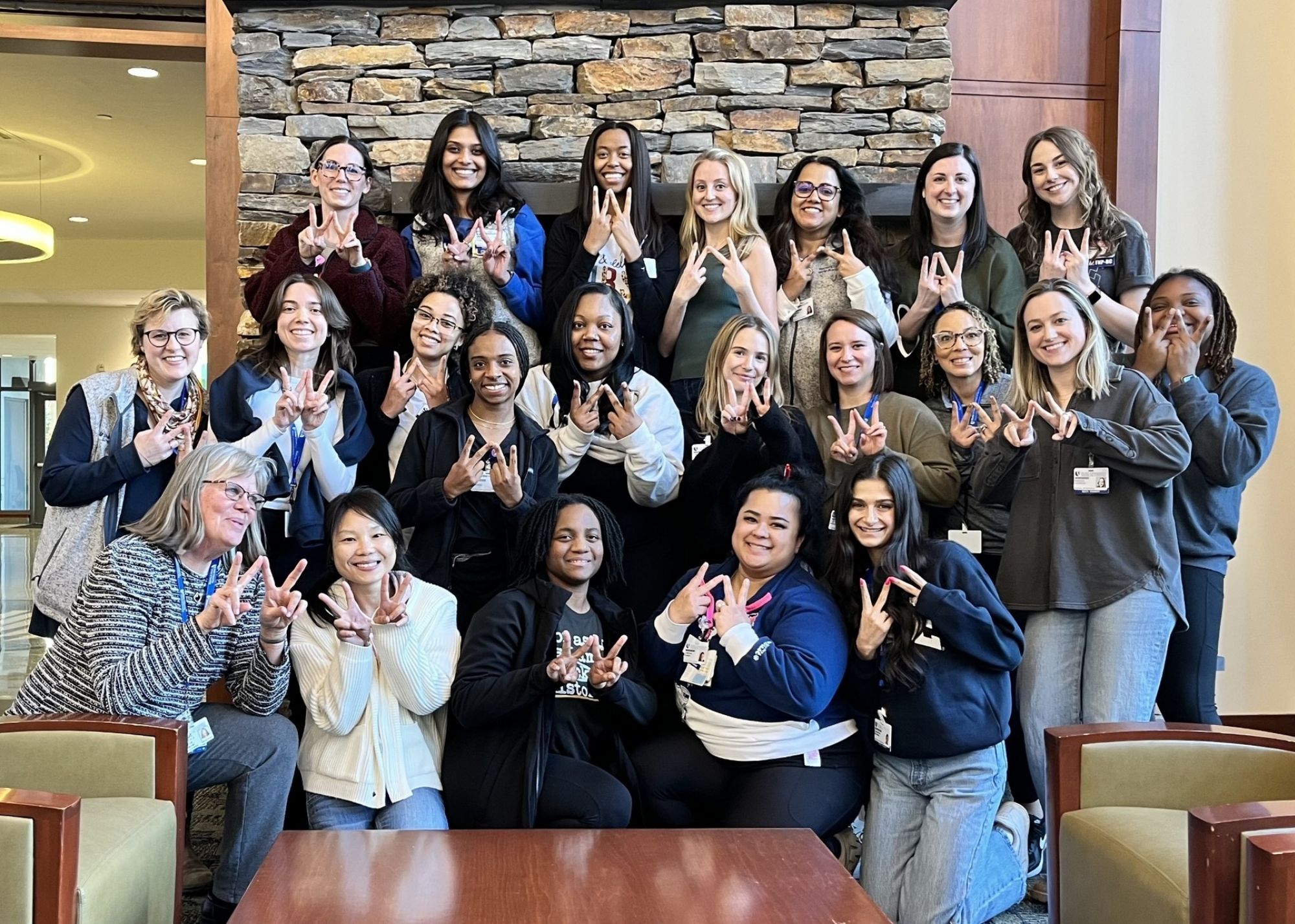 WHNP Class of 2025, with their fingers shaped in a "W" for "women's health"