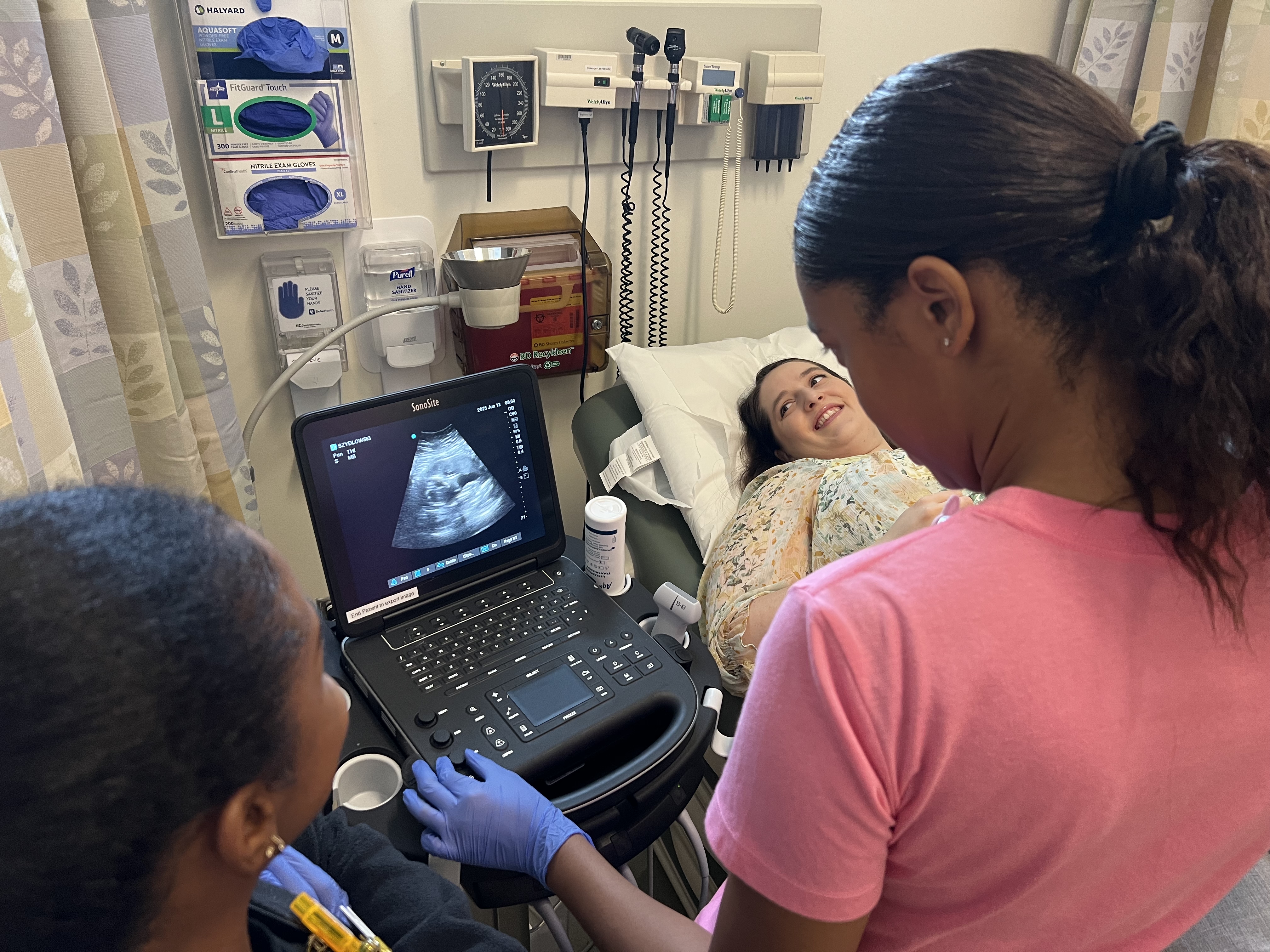 Volunteer and students look at an ultrasound display