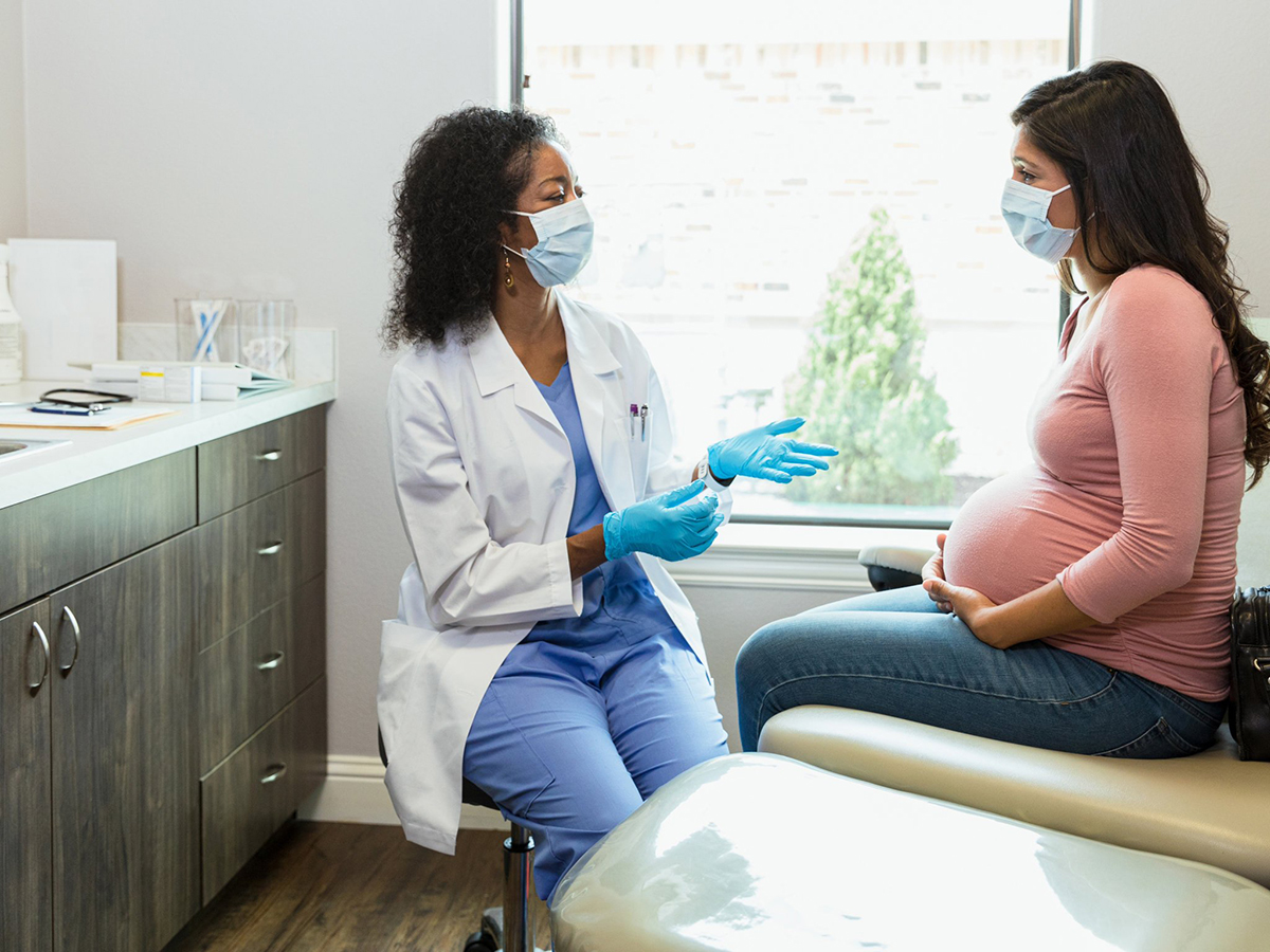 Nurse with mask talking with patient