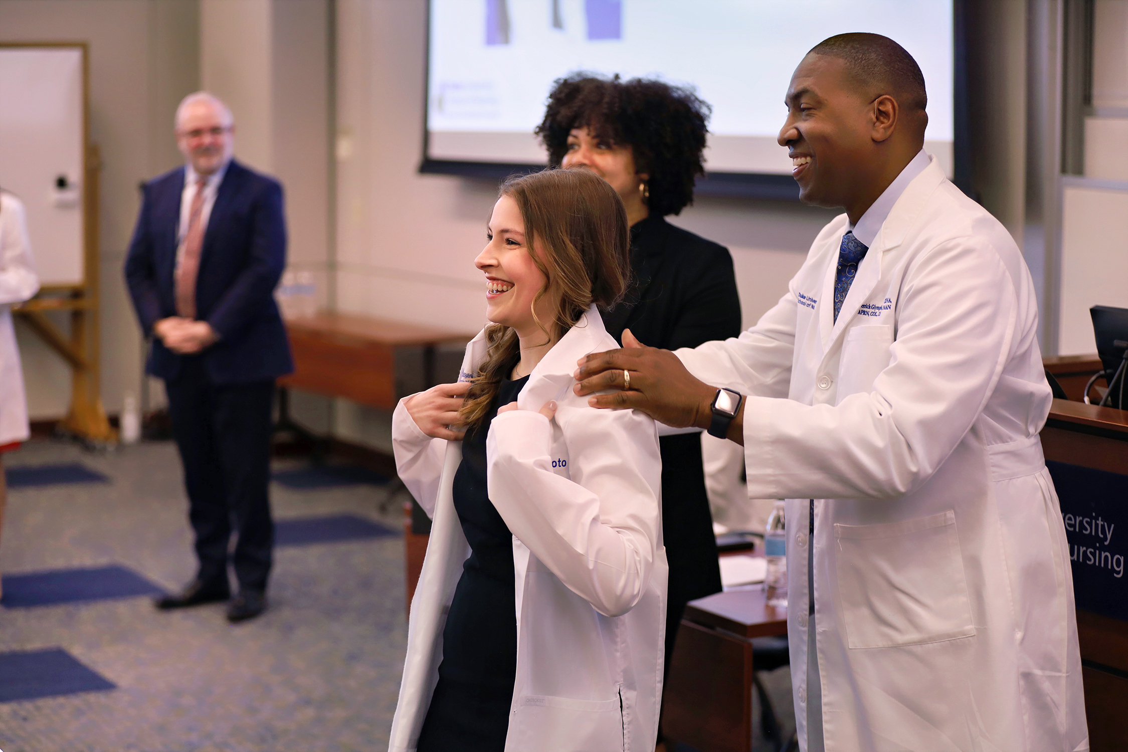 Derrick Glymph puts white coat on Duke University School of Nursing CRNA student