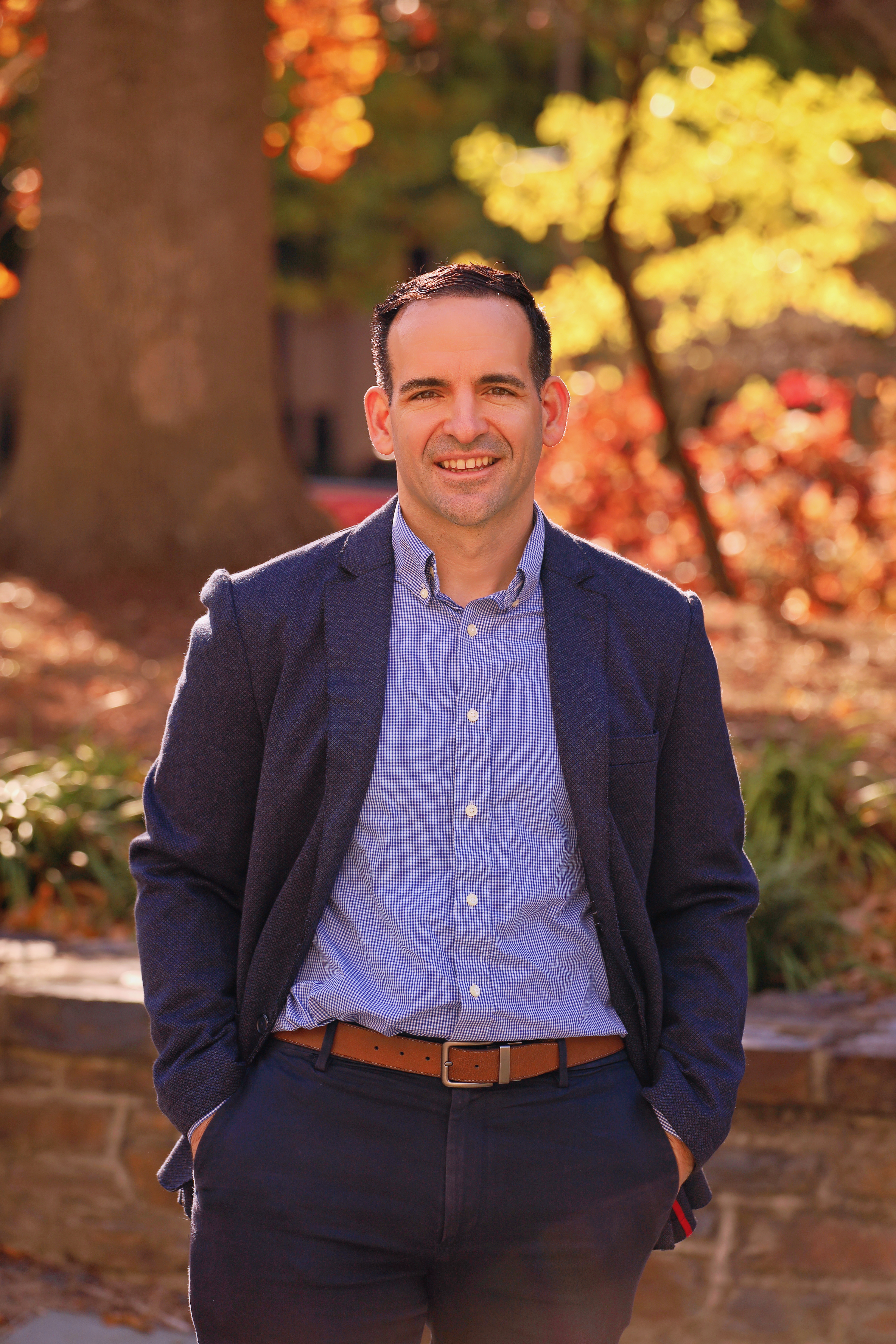 Dr. Brandon Knettel outside in front of fall foliage