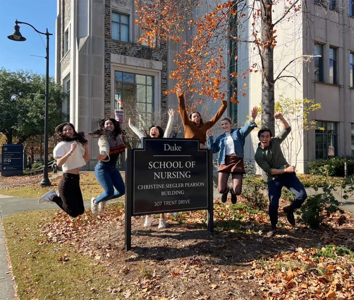 Nursing Students jumping in the fall leaves