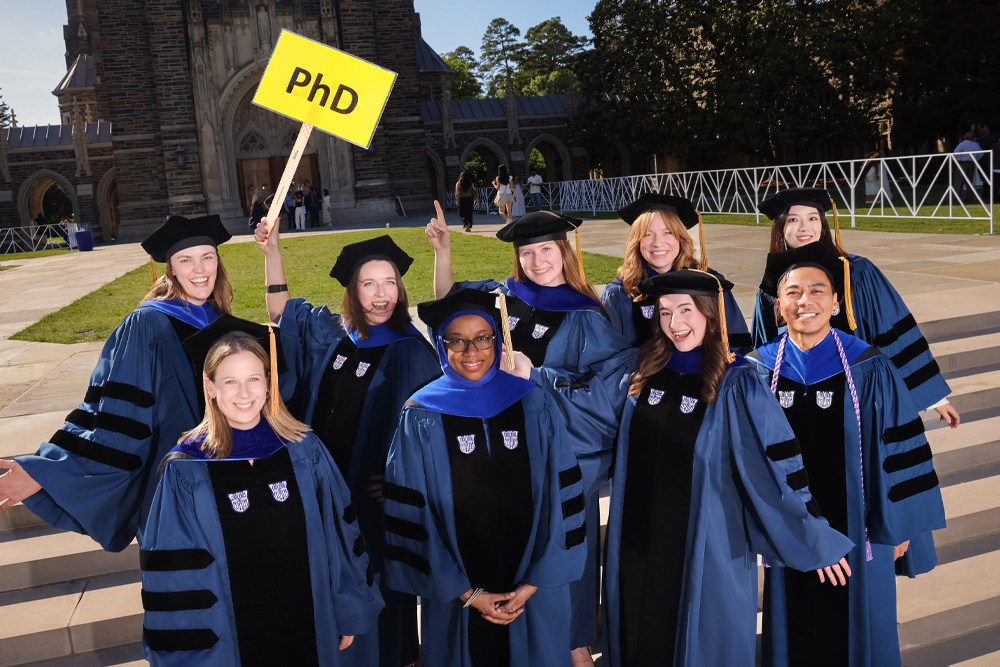 PhD Graduating class of 2026 pose for a happy candid photo