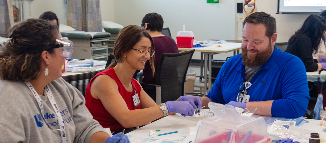 Faculty memeber helping students during a class workshop