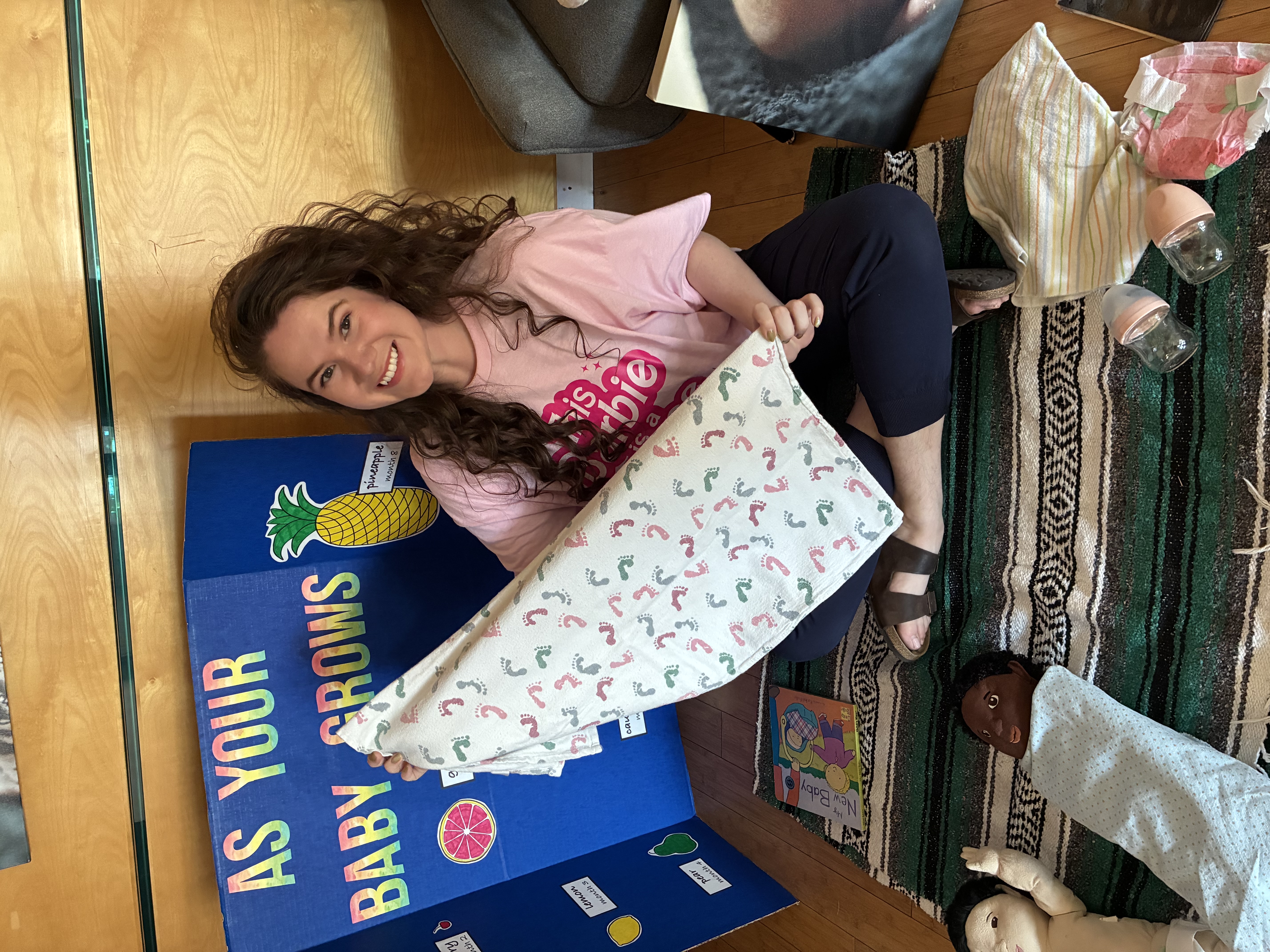 Reesa Artz in front of a doula sign holding a baby doll