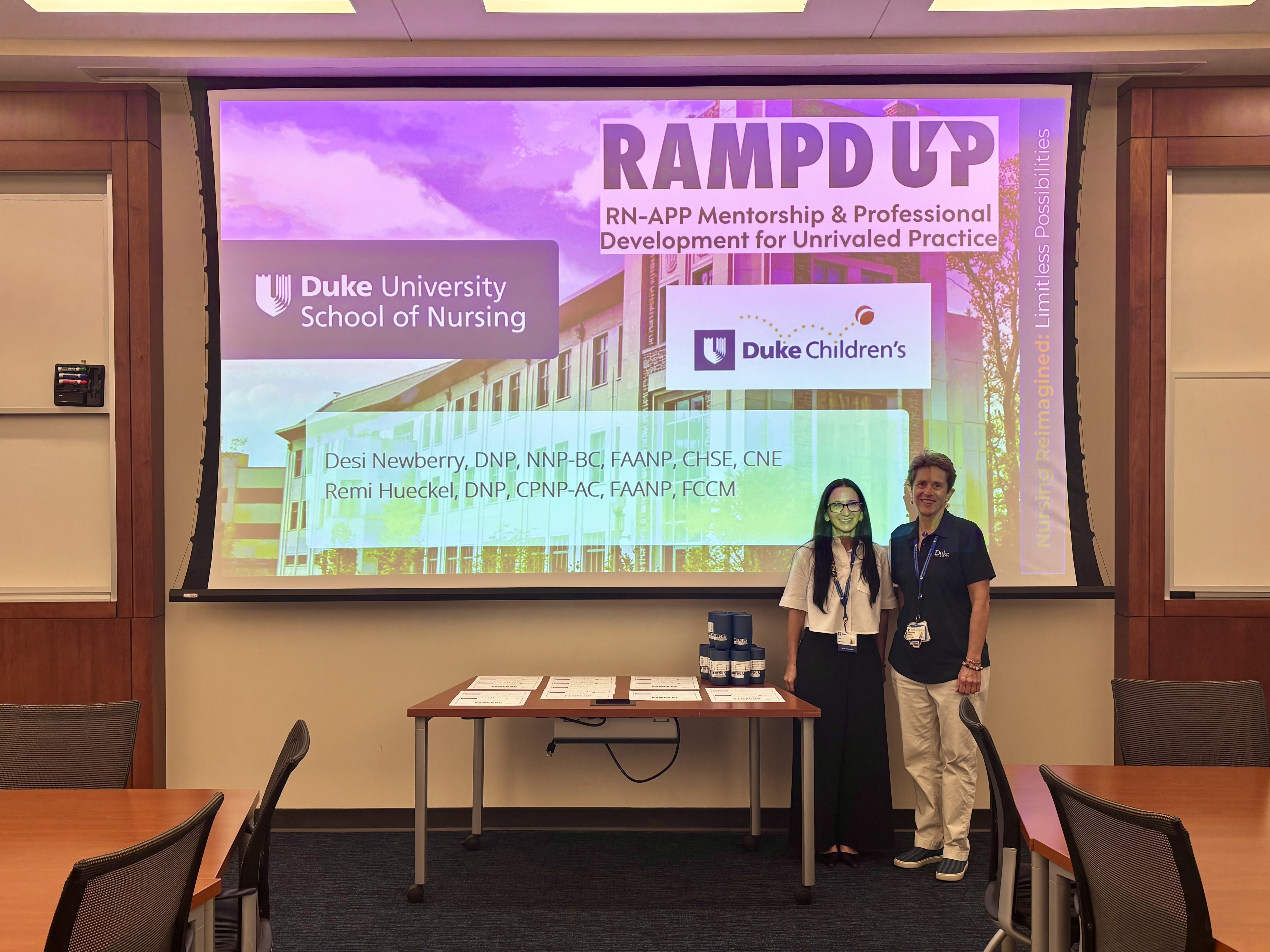 Drs. Newberry and Hueckel in front of a RAMPD-UP Powerpoint