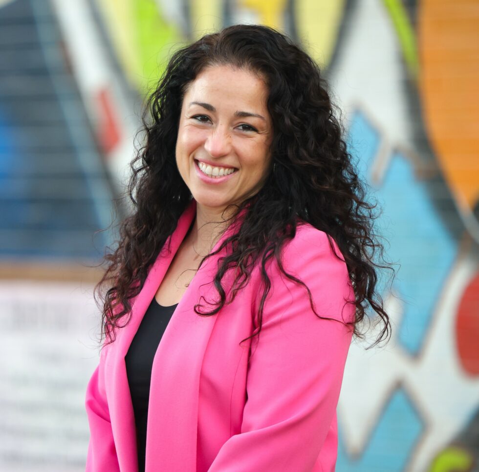 Rosa Gonzalez-Guarda headshot in front of mural