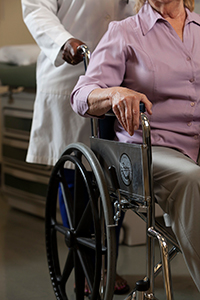 medical provider pushing patient in wheelchair