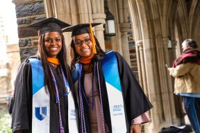 two women in graduation cap and gowns 