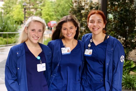 three female students standing outside