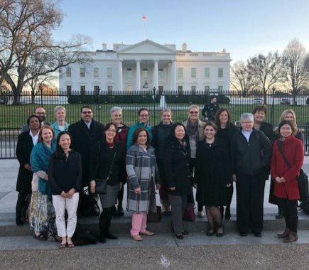 group standing in front of white house