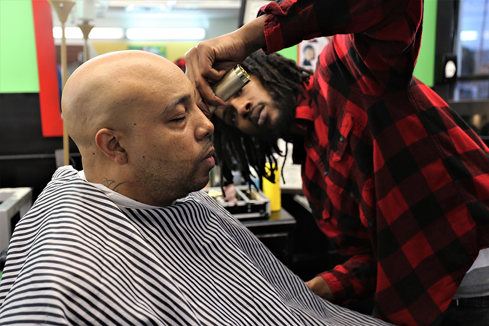 man gets his head shaved by male barber in durham barbershop