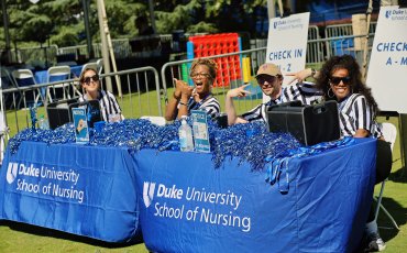 School of Nursing Staff joking at the sign in table