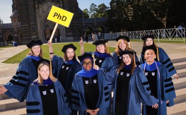 PhD Graduating class of 2026 pose for a happy candid photo