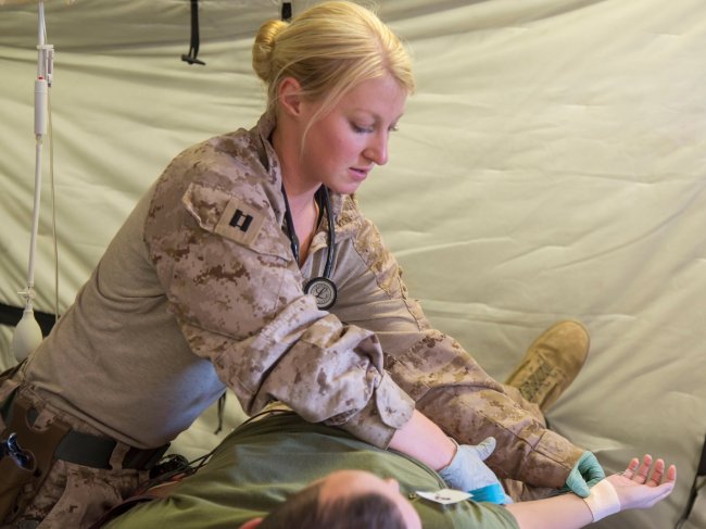 Erika Grattidge attends to a patient while an active military duty