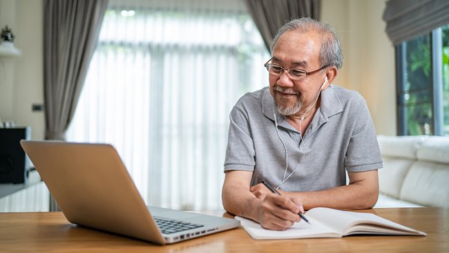 Older adult studying while using a laptop