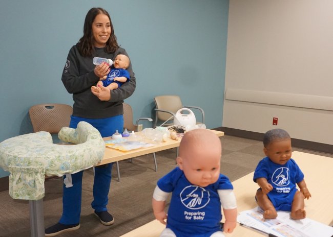 Jacqueline Lawdley demonstrates bottle-feeding using a baby doll