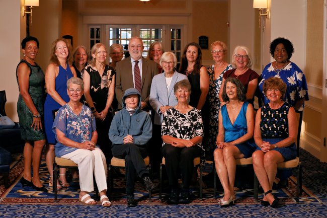 New faculty emeriti and returning faculty emeriti sitting and standing in lobby of Washington Duke Inn