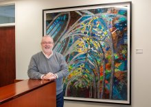 Dean Michael Relf in front of a framed quilt