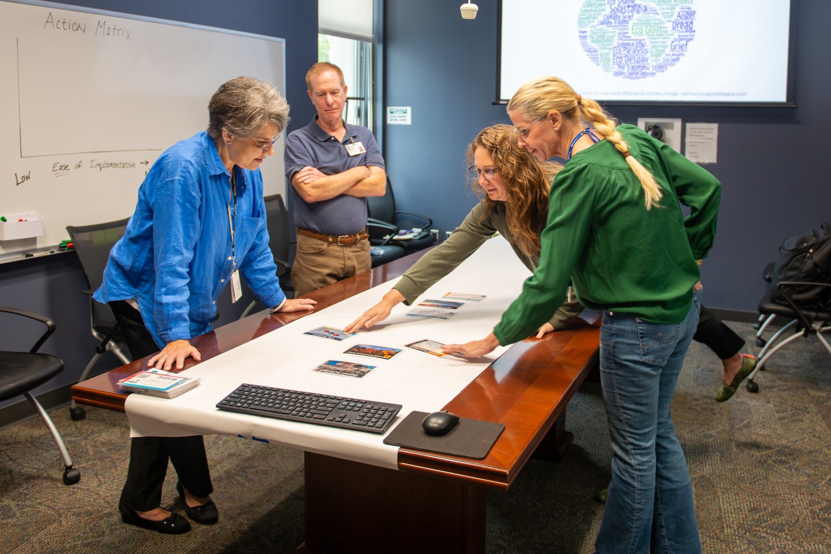 Valerie Sabol stands at a table with a man and two women looking down at plans