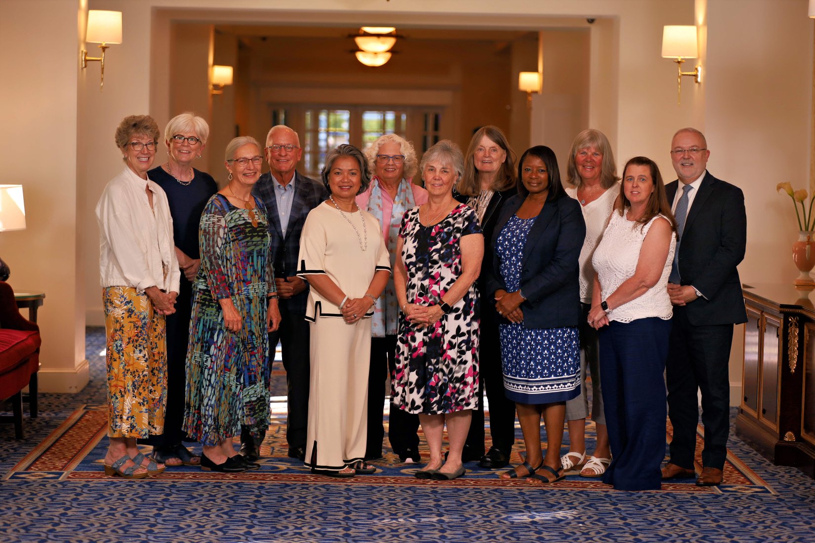 Faculty and staff at the Vicennial Celebration stand in the hallway at the Washington Duke Inn