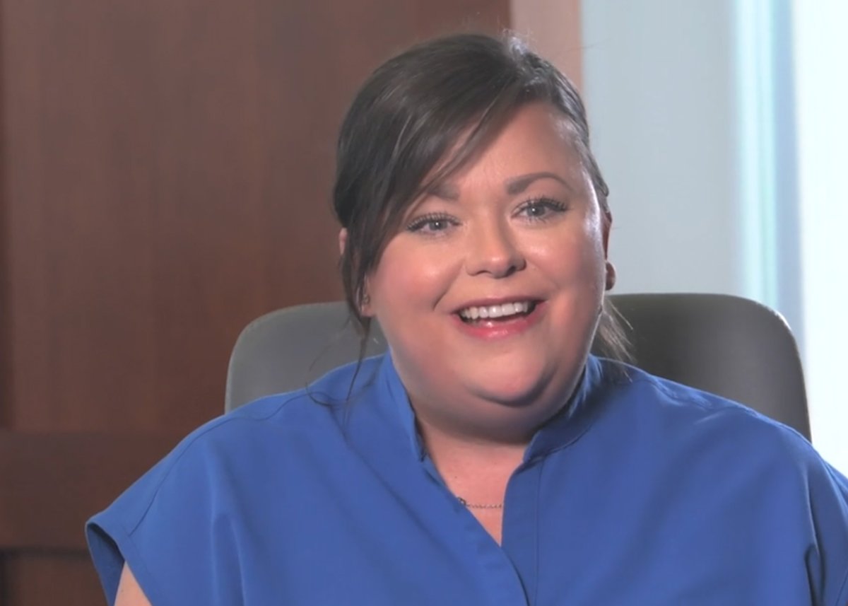 Amber Whitfield wearing blue scrubs and smiling