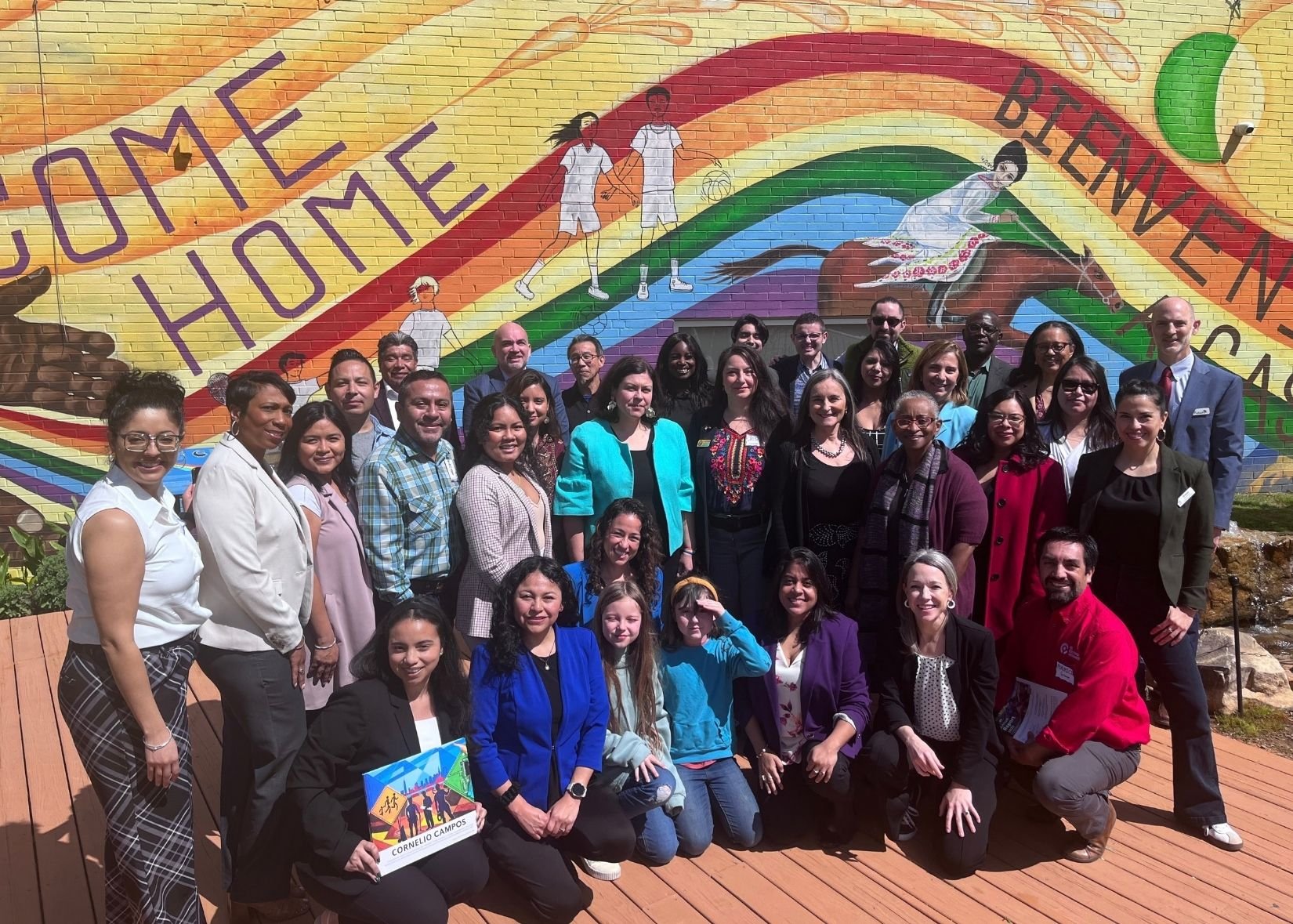 Group photo in front of colorful mural