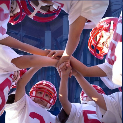 Stock image of youth in American football gear in a huddle