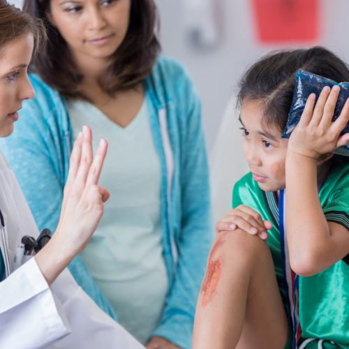 Medical professional examing child with head injury Medical professional examing child with head injury